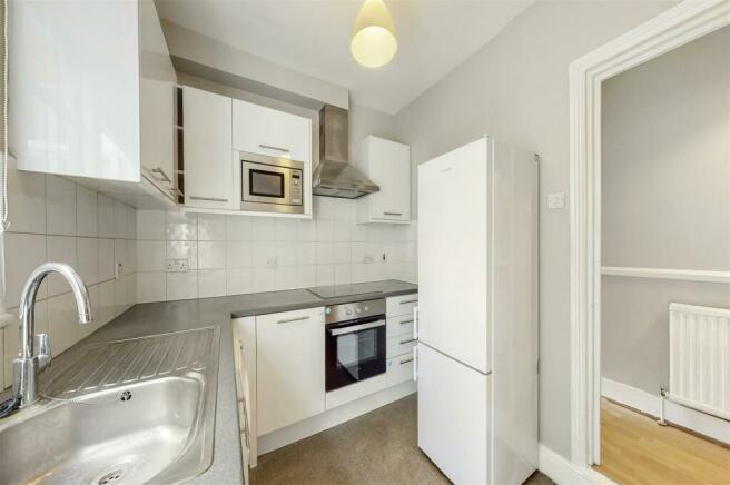 Fitted white lacquered kitchen with door to garden