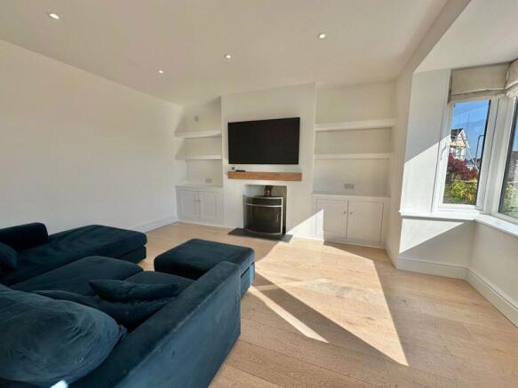 Living room with bay window and firep...