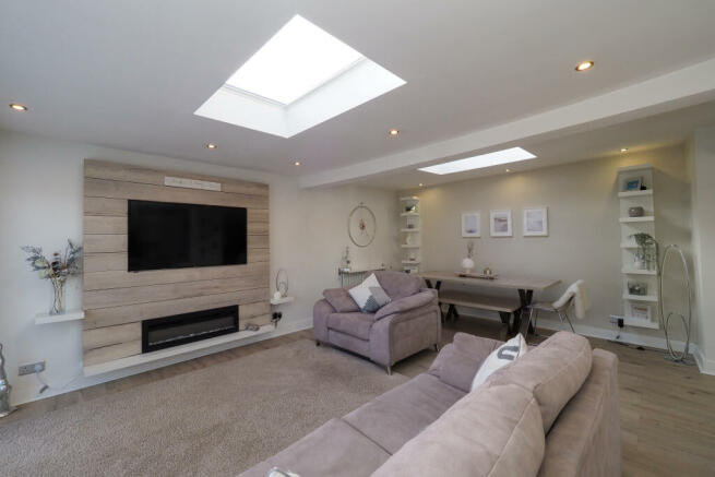 This soft and naturally light extended living space is stunning, lounge with feature media unit and dining area.