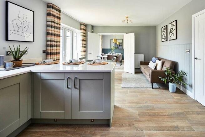 An open plan kitchen and dining area leads through double doors to the garden