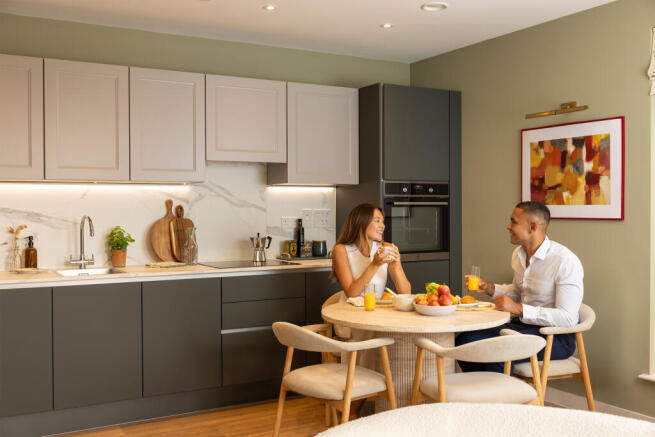 couple sat at the dining table next to the kitchen having breakfast together