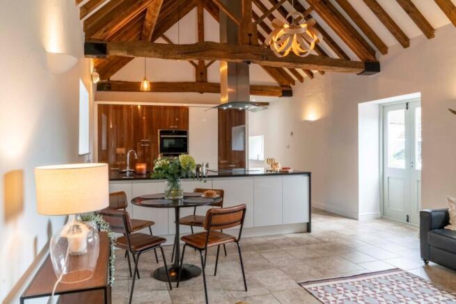 Open living kitchen with rustic beams to the eaves offering height