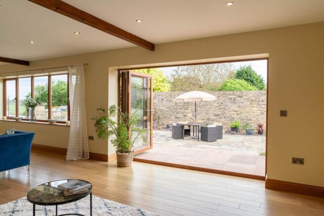 Bi-folds opening onto the sunny courtyard from the bright lounge