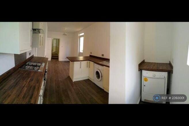 An Open Plan Dine In Kitchen With a Laundry Corner