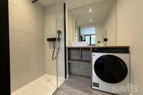 A modern bathroom features a glass-enclosed shower