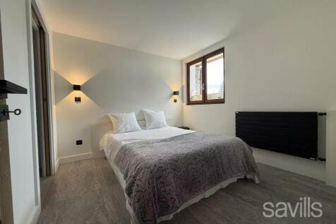 A minimalist bedroom with a double bed, light gray