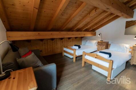 The image shows a cozy attic room with a wooden ce