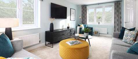 Bright living room with light blue walls, large windows, grey sofas, colourful cushions, and modern