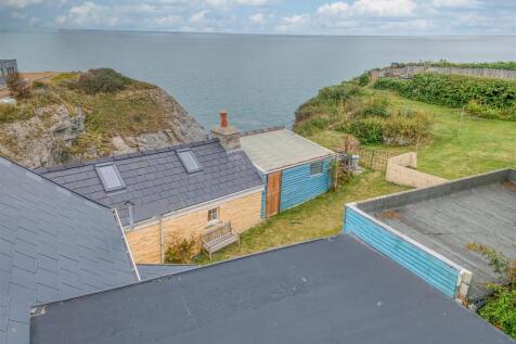 Aerial view out to sea and the stone cottage