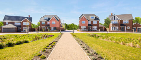 Modern suburban houses with well-maintained gardens and a central pathway in a sunny neighbourhood a