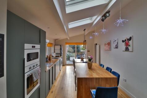 Extended Vaulted Island Kitchen matt green cupboar