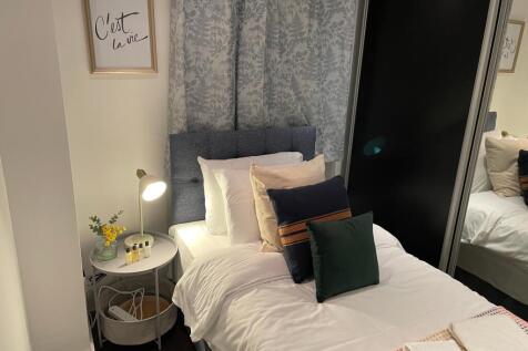 A cozy and well-lit double bedroom featuring st...