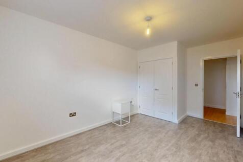 A bright double bedroom featuring a built-in wa...