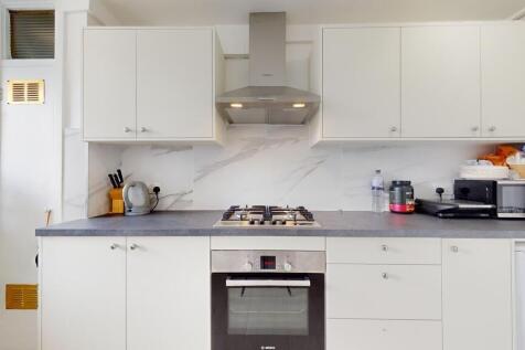 Bright and clean kitchen featuring modern white...