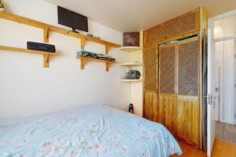 A cozy bedroom featuring a neatly made bed with...