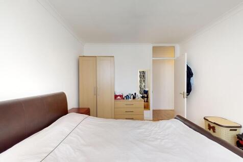 A bright and tidy bedroom featuring a large bed...