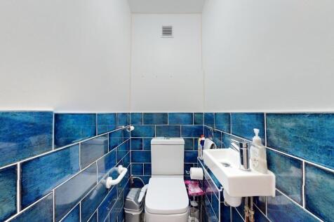 Compact but well-maintained bathroom with blue ...