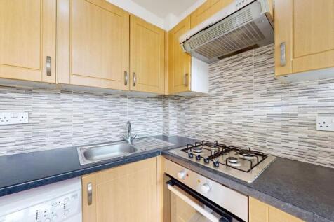 A well-maintained kitchen with wooden cabinets,...