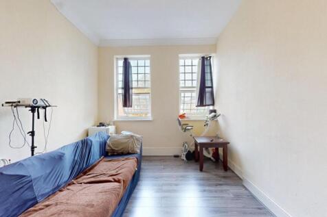 A cozy living room featuring two windows that b...