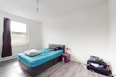 A simple, neat single bedroom featuring a comfo...