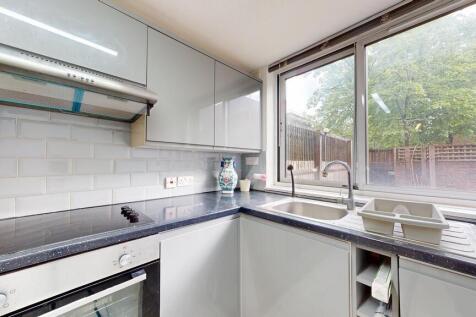 Modern U-shaped kitchen with glossy cabinets, a...