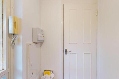 Bright, clean entrance hallway with a white pan...