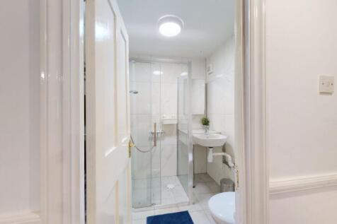 Bright, modern bathroom with a glass-enclosed s...