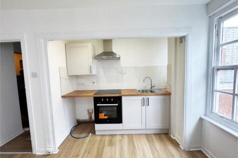 Bright, modern kitchenette with wood-effect wor...
