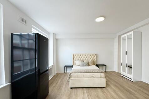 Bright, modern double bedroom with a plush upho...