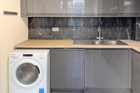 Modern kitchenette with grey gloss cabinets, wo...