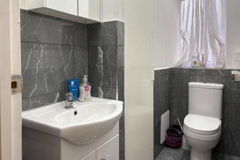 Clean, modern bathroom with grey marble-effect ...