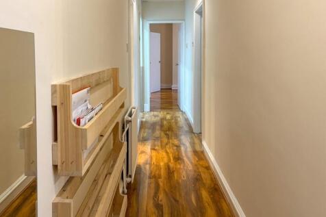 Bright, well-maintained hallway with warm wood-...