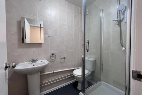 A modern and clean bathroom featuring a shower,...