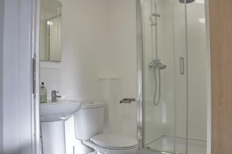 A modern and clean bathroom featuring a glass s...