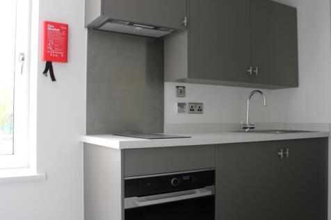 A modern kitchenette with sleek cabinetry and a...