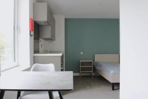 A bright and modern double bedroom with a styli...