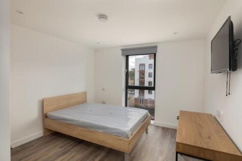 A bright and modern double bedroom featuring la...