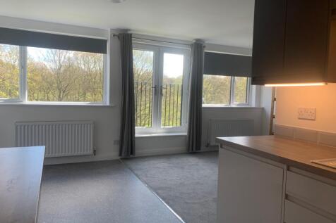 Bright and spacious living room featuring large...