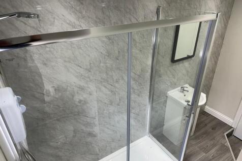 Modern bathroom featuring a sleek shower enclos...