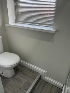 A clean and tidy single toilet featuring modern...
