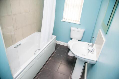 Bright and airy bathroom suite featuring a comf...