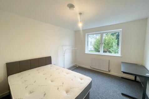 This spacious double bedroom features a comfort...