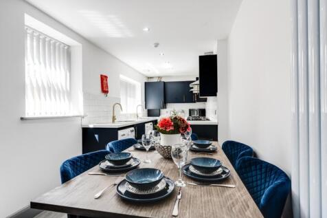 A modern and stylish kitchenette with ample nat...