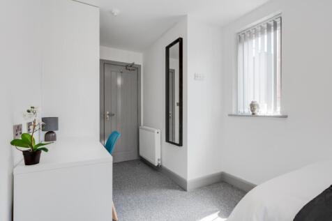 A bright and tidy double bedroom featuring mode...