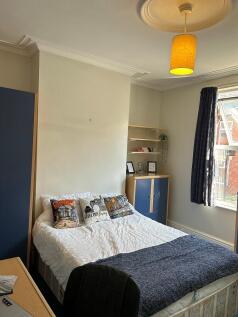 This inviting double bedroom features a cozy be...