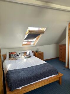 This cozy double bedroom features a comfortable...