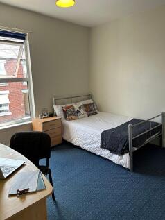 This inviting double bedroom features a cozy at...