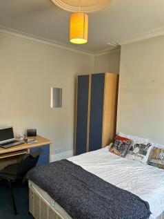 This cozy double bedroom features a comfortable...