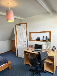 This inviting double bedroom features a cozy be...
