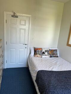Cozy single bedroom featuring a comfortable bed...